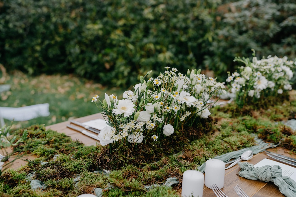 Blumenarrangement aus Moss und weißen Blumen