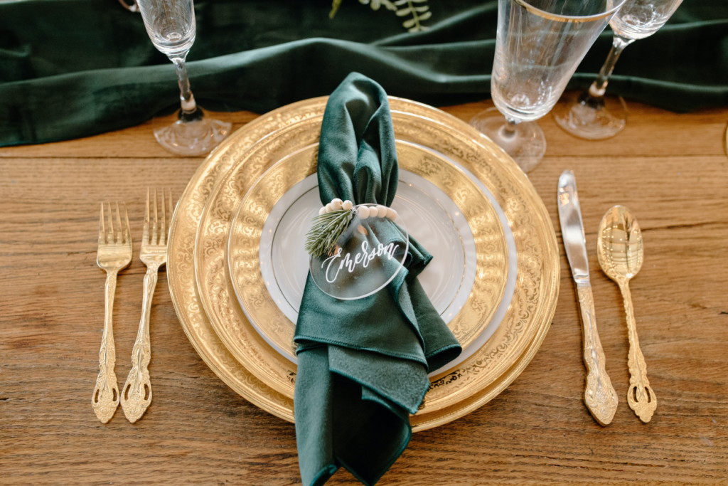 goldene Platzteller mit grüner Satin-Serviette