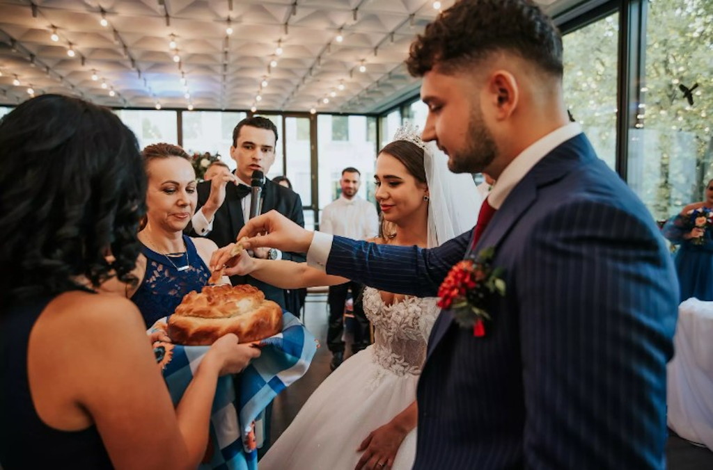 Brot-und-Salz-Empfang (Karawaj) - das Brautpaar bricht das Brot bei einer russischen Hochzeit in K&ouml;ln